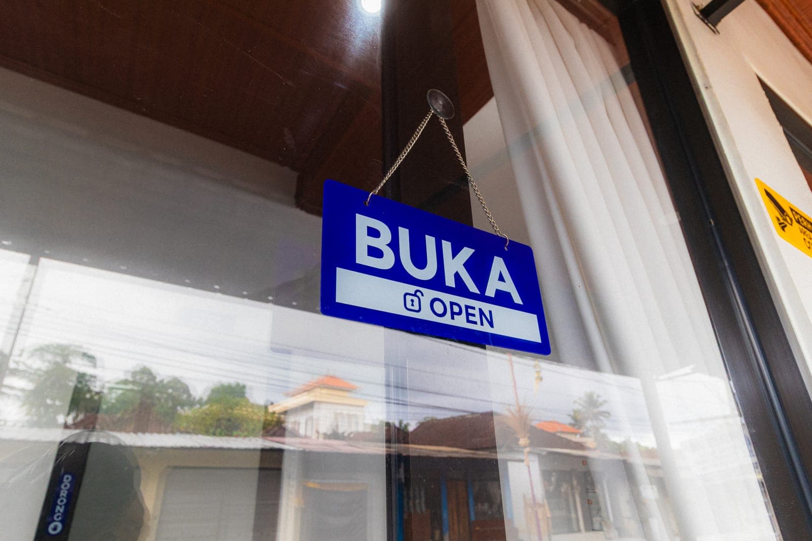 Papan tanda BUKA di pintu masuk